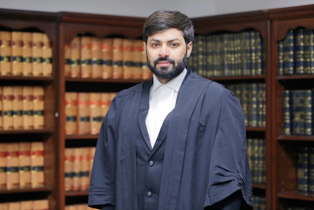 Advocate Akash Chaudhary in court attire, standing before a law library